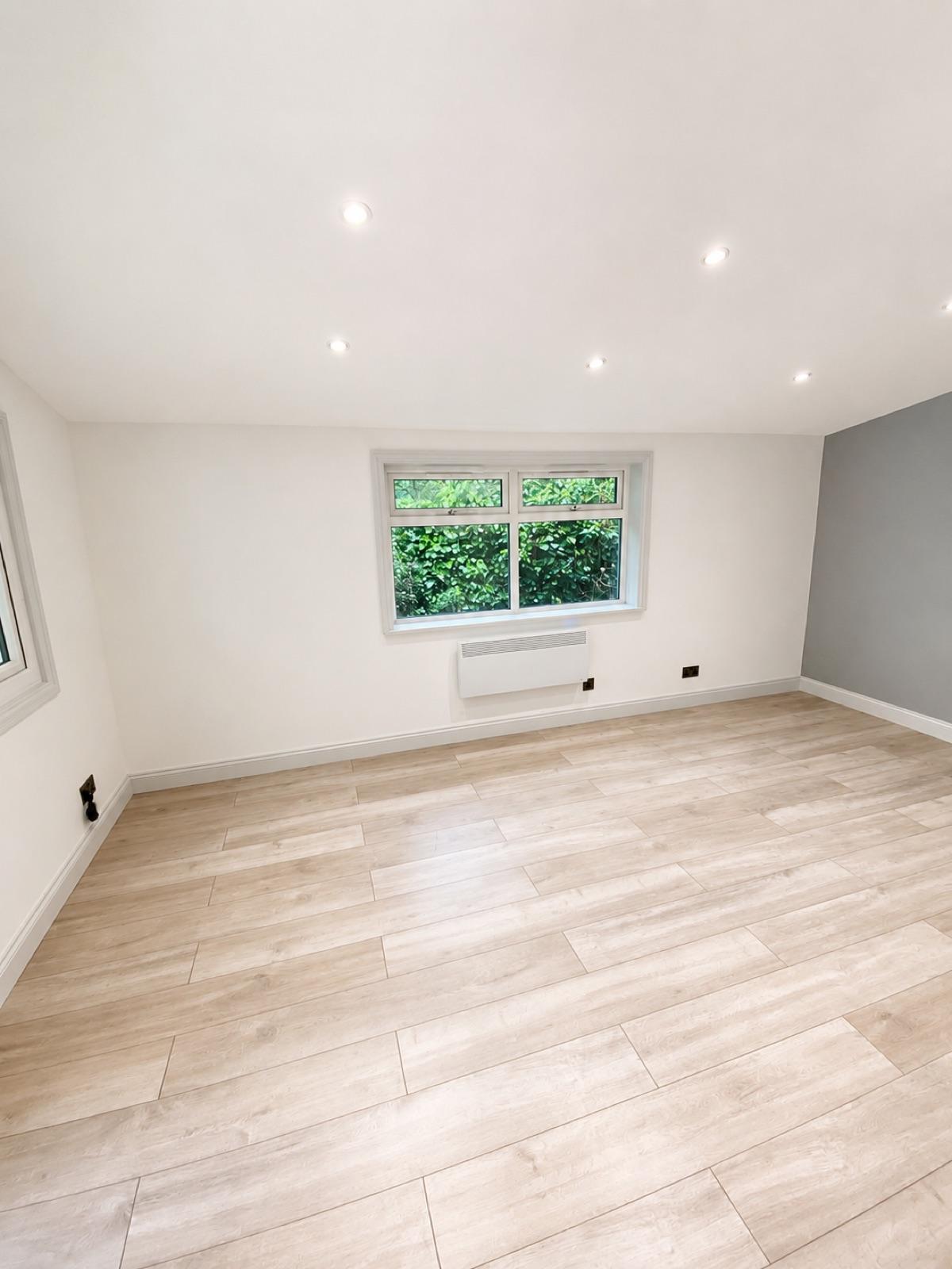 A finished, decorated interior with bright walls and wood-effect flooring.